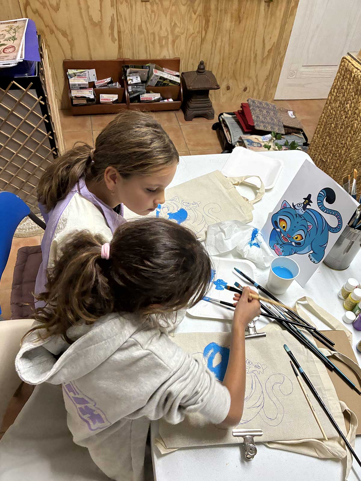 Cursos creativos CupCanvas grupo niñas pintando gato totebag